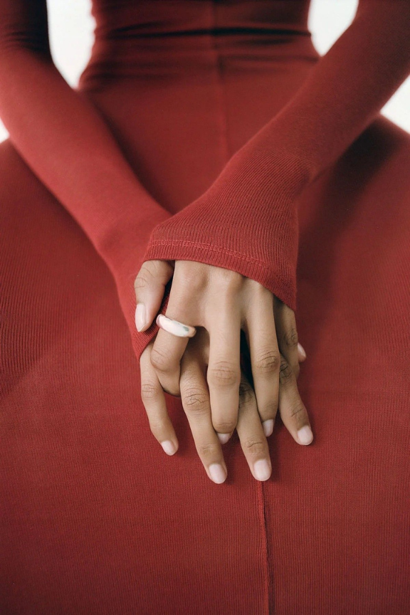 Hands crossed in a red dress
